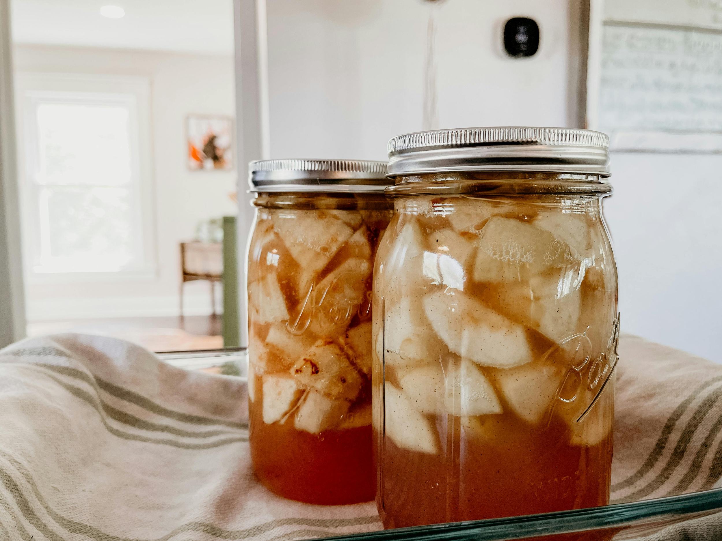 Jars of homemade apple pie filling cooling after canning